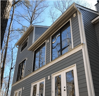Two-story house with dark blue horizontal siding and white trim.