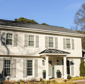 Two-story house with mixed siding and gray shutters installed by siding contractors.