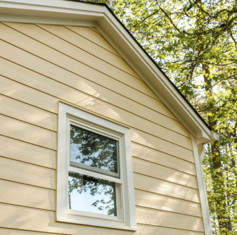 House with yellow siding and a window Nelson Exteriors in Atlanta, GA