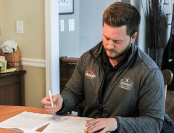 Nelson Exteriors team member reviewing and signing project paperwork in Marietta, GA